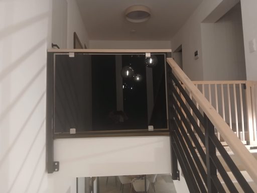 Treppengeländer Geländer in einem Flur mit dunklem Hintergrund und einer Lampe oben.