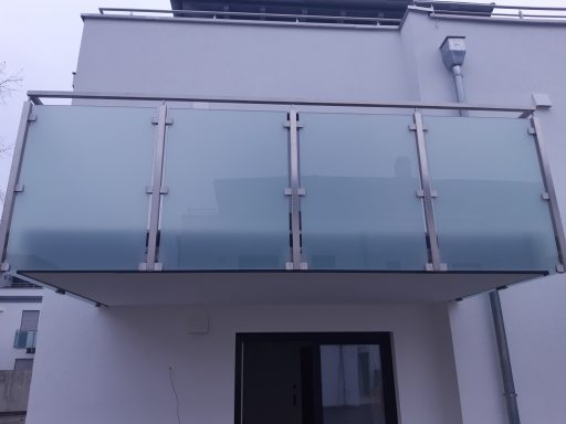 Balkongeländer Balkon mit Glasgeländer an einer modernen, weißen Fassade.