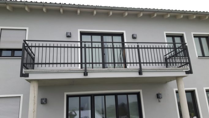 Balkongeländer Balkon mit schwarzer Geländer und großer Fensterfront an einem modernen Haus.