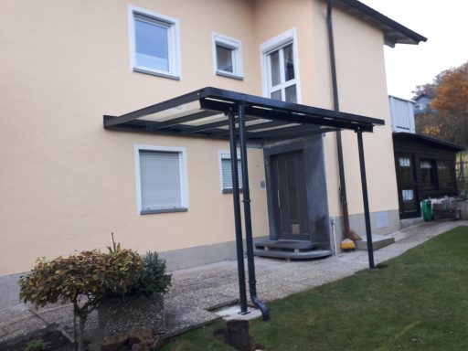 Vordach Ein modernes Vordach über einem Eingang zu einem Haus mit hellem Außenanstrich.